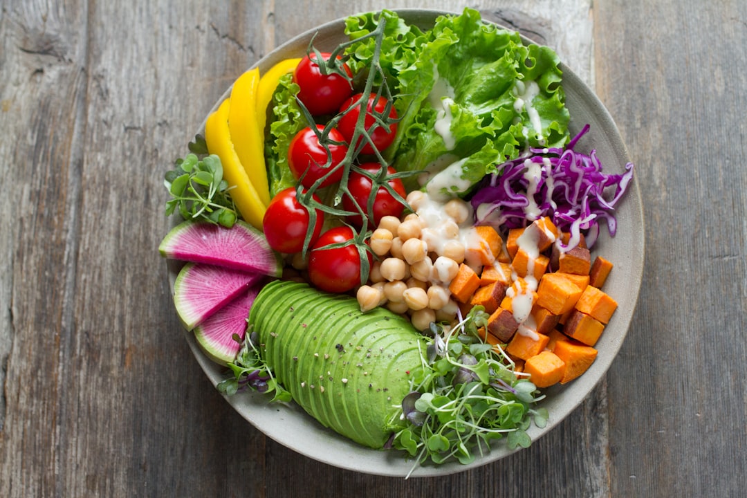 A colorful salad bowl filled with a variety of fresh vegetables, including tomatoes, avocado, and leafy greens, set on a